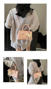 Pink matte leather crossbody bag featuring a pearl lace heart charm and dual handles