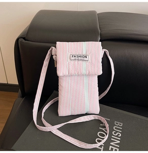 Detail view of quilted pink striped crossbody phone bag with Fashion Instinct label