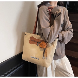 Detalle de bolso tote de lona con correas de cuero y un tierno oso de peluche marrón