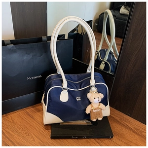 Detail of Boston bag with navy nylon fabric, white leather trim and cute teddy bear charm
