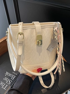 Sac seau minimaliste en cuir blanc crème avec détails dorés et charms élégants