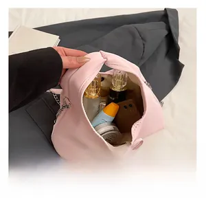 Pink synthetic leather bag with knotted handle showing internal capacity for daily items