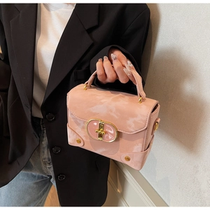 Detail view of pink marble texture handbag with gold metal lock and leather handle