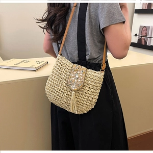 Detail of straw woven bag featuring colorful sequin patterns and elegant long tassels