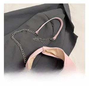 Close-up of pink PU leather handbag with metal chain and elegant bow drawstring detail