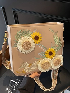 Beige bucket bag with 3D sunflower embroidery and a wide geometric woven strap
