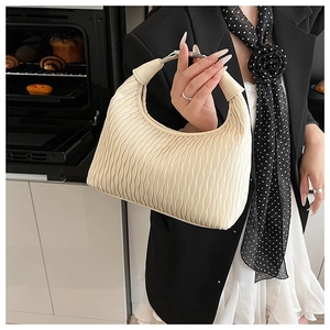 Detailed view of cream off-white pleated handbag with artistic wavy texture and crescent shape