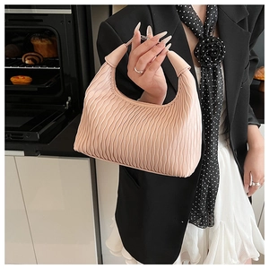 Detail of pink pleated handbag showing vertical wave texture and soft leather texture