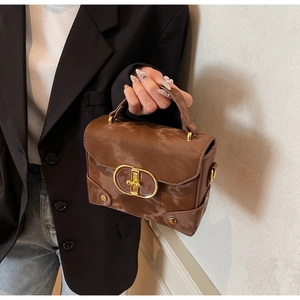 Detail view of brown marble pattern texture on premium box bag with gold metal clasp