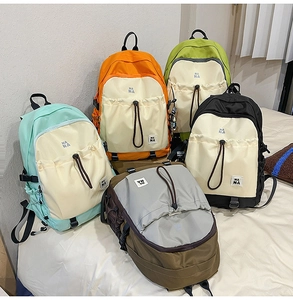 Dettaglio di cinque colori di zaini in nylon impermeabile con tasche a coulisse e fibbie
