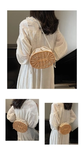 Detail of woven straw bag featuring white pearl strap and canvas drawstring liner