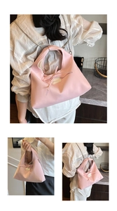 Detail showing the pink dumpling bag with a delicate bow and sleek metal chain strap