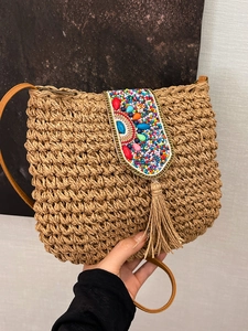Handmade straw crossbody bag with colorful beadwork and long tassel detail for vacation
