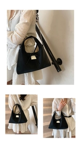 Detail of black nylon dumpling bag featuring a decorative bow and metallic chain strap