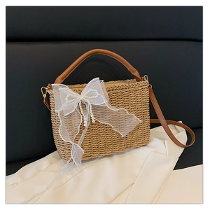 Close-up of woven straw texture with white lace bow and faux pearl accents on the bag