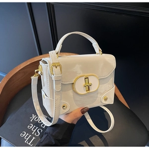 Detailed macro view of cream box bag with glossy finish and elegant golden lock