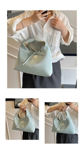 Close-up of light blue dumpling bag with elegant ribbon bow and gold chain strap