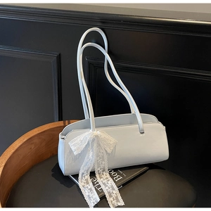 Detail einer hellblauen Baguette-Tasche mit einer zarten weißen Spitzenschleife