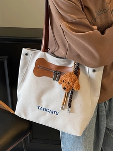 Bolso tote de lona versátil con correas de cuero marrón y colgante de perrito de peluche