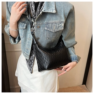 Detail of the black pleated leather hobo bag with vintage texture and soft shoulder strap