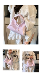 Detail of light purple glossy dumpling bag with bow decoration and metal chain strap
