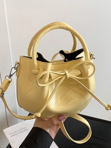Chic yellow oiled leather bucket bag with ribbon bow and adjustable shoulder strap