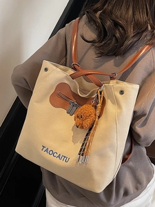 Versátil bolso tote y mochila de lona beige con correas de cuero y colgante de osito