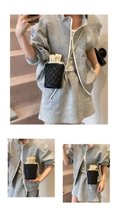 Detail view of quilted bucket bag with gold chain strap and interior drawstring closure