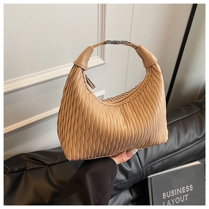 Detailed view of beige pleated hobo bag featuring vertical folds and silver metal buckle