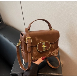 Detail view of a vintage brown box bag with frosted texture and gold oval twist lock