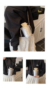 Detail of silver quilted bucket bag featuring a beige drawstring and gold chain strap