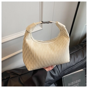 Close-up of beige pleated handbag texture with silver metal buckle detail