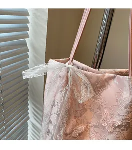 Dettaglio della borsa tote jacquard rosa con motivi a farfalla 3D e fiocco in pizzo bianco