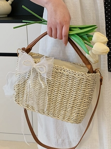 Straw handbag with white lace bow, pearl trim, and brown leather straps for summer beach