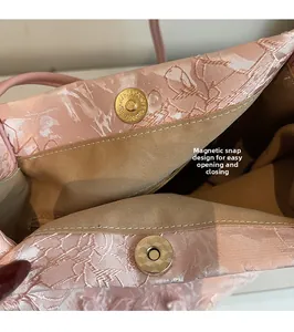 Dettaglio della borsa tote in jacquard rosa con chiusura magnetica dorata sicura
