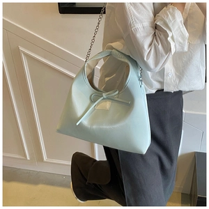Detail of light blue mint leather dumpling bag with bow decoration and silver metal chain