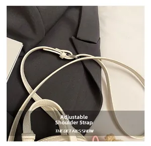 Detail showing adjustable white faux leather strap with silver buckle on shoulder bag