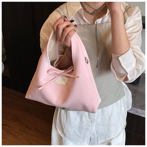 Detail of pink PU leather dumpling bag with bow decoration and stylish chain strap