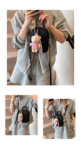 Detail of black pebbled leather phone bag with cute pink teddy bear charm accessory