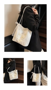 Dettaglio ravvicinato di una borsa tote in pizzo bianco con farfalle 3D e un fiocco chic