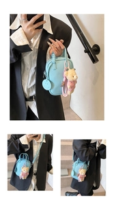 Detail of light blue litchi grain mini bag with cute pink bear and smiley face charm