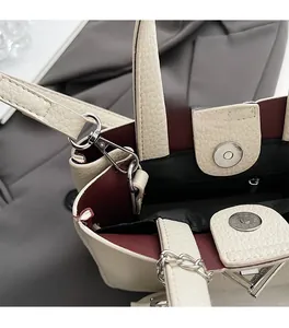 Detail view of lychee leather bucket bag with silver hardware and burgundy lining interior