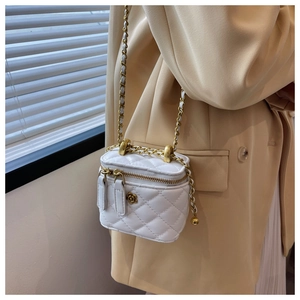 Detail of white quilted mini bag with gold chain strap and floral metal clasp