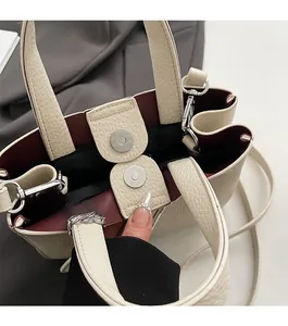 Detail of lychee pattern handbag with magnetic clasp closure and burgundy inner lining