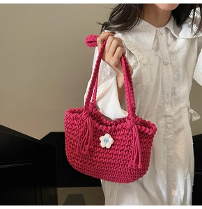 Detail of hand-woven dark pink cotton tote bag with flower charm and bohemian tassels