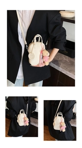 Close-up of cream crossbody bag with lychee texture leather and plush bear charm