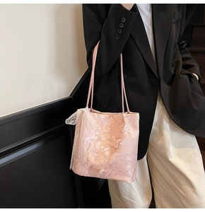 Borsa tote in pizzo rosa con ricamo a farfalla 3D e motivi floreali indossata da modella