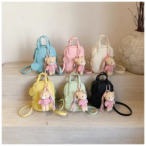 Detailed macro view of colorful textured leather mini bags with cute bear charms