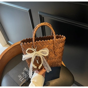 Détail du sac cabas marron tissé à la main avec nœud en dentelle de perles et bords dentelés