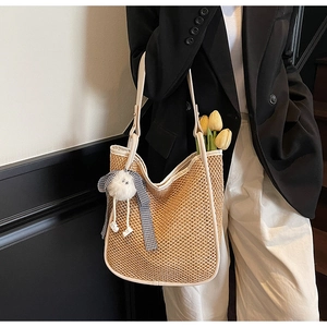 Vue détaillée du sac cabas en paille tissée avec bordure en cuir blanc et ruban à carreaux